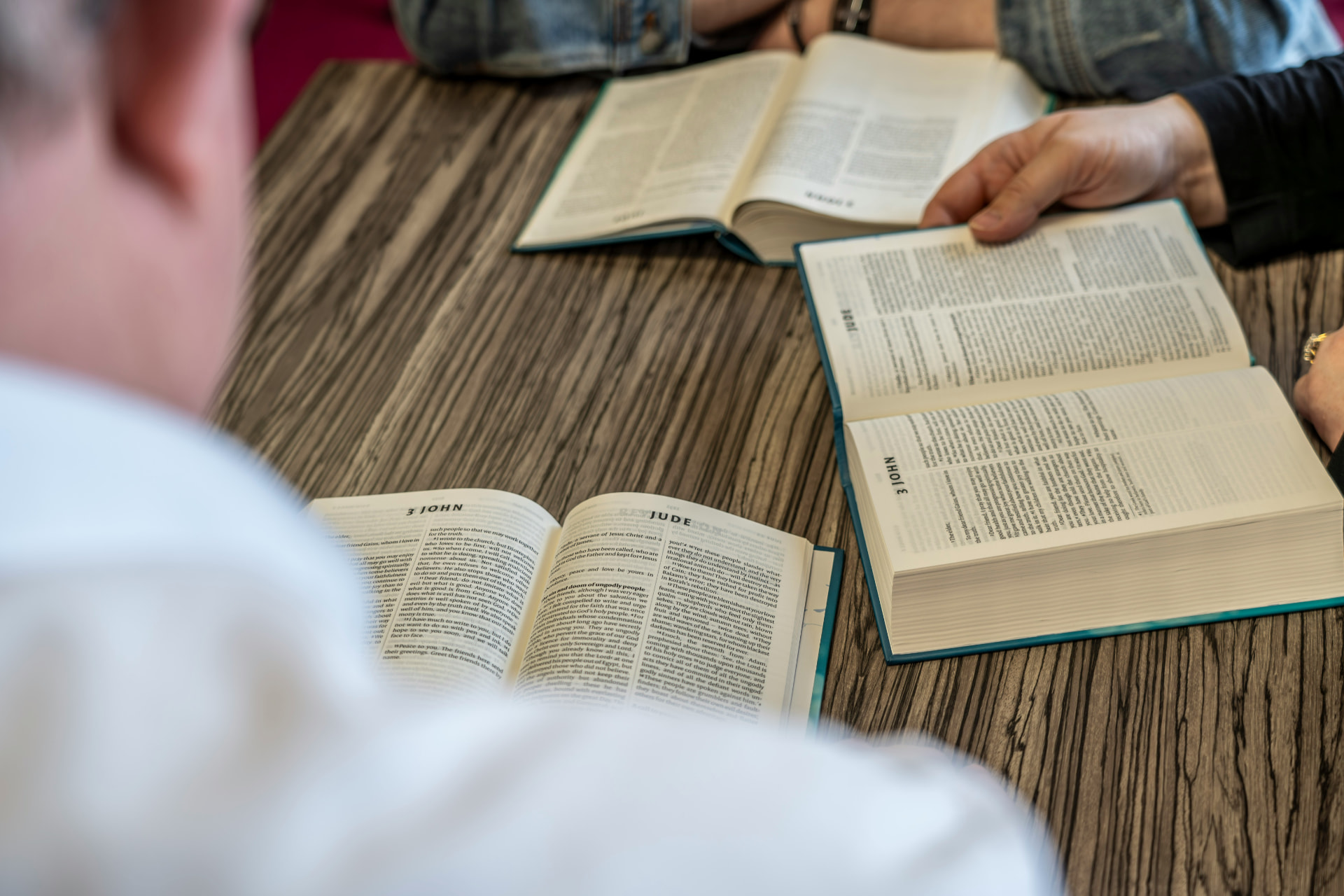 Open Bibles on a wooden table during a Cornerstone small group gathering
